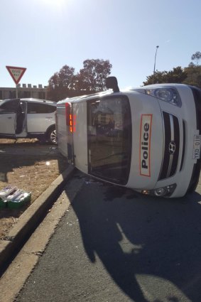 A police van rests on its side after a crash in Phillip on Wednesday morning.