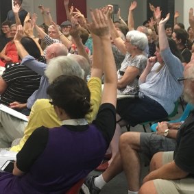More than 50 residents raise their hands to indicate support for a boycott of the the Pig ‘N’ Whistle pub.