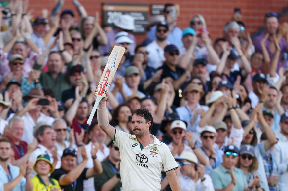 Travis Head raises his bat in Adelaide.