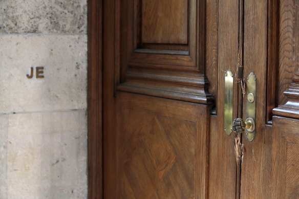 The front door to the New York  mansion that was owned by Jeffrey Epstein, marked with "JE". Police damaged the doors when they broke in to investigate the "protective fortress of power" before his arrest.