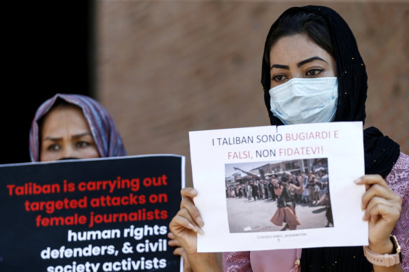 Members of the Afghan community in Rome hold up posters including one with writing in Italian “The Taliban are liars and false, don’t trust them!“, during a demonstration. 