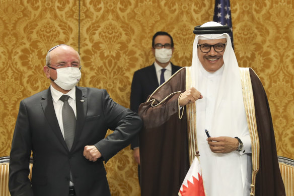 Israel's national security adviser, Meir Ben-Shabbat (left) bumps elbows with Bahrain's Foreign Minister Abdullatif al-Zayani after signing an agreement in Manama, Bahrain, on Sunday.