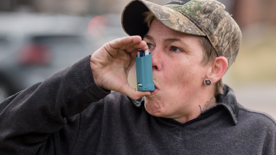 Moo Blake takes a dose of an inhaler in East Palestine, Ohio. Blake was diagnosed with bronchitis due to chemical fumes after the spill.