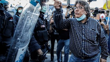 Police face a group of demonstrators protesting against the hard economic conditions in front of the Lombardy region headquarters, in Milan, Italy. 