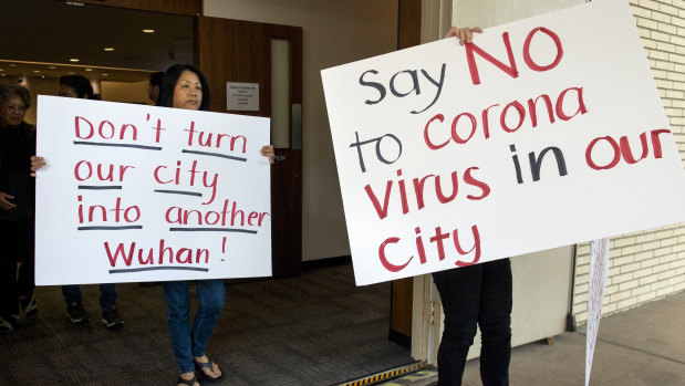 Mary Cahill, left, leaves a news conference where officials discussed the proposal for housing coronavirus patients at the Fairview Development Center in Costa Mesa, California.