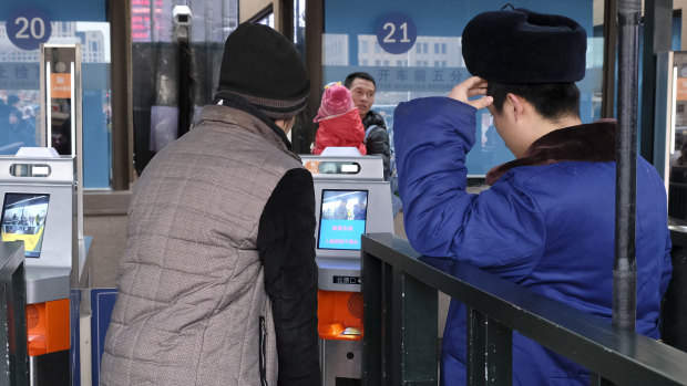 Train travellers are confronted by a new facial recognition system as they travel home from Beijing for Chinese New Year. 