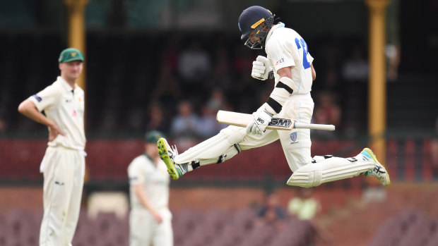 Young runs: Jason Sangha leaps in celebration after reaching his century against Tasmania.