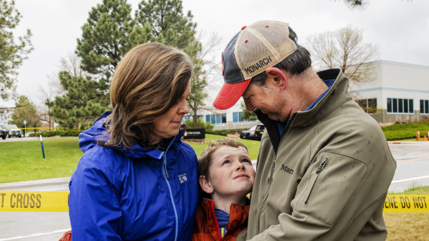 Kelly and Steve Holley hold their son Nate, 12, across the street from the STEM School Highlands Ranch in Highlands Ranch, Colorado. 