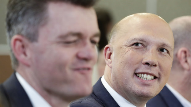 Australian Federal Police Commissioner Andrew Colvin (left) with Home Affairs Minister Peter Dutton. A public servant whose home and office was raided in relation to Mr Dutton's au pair saga has written to Mr Colvin alleging the investigation was politically biased.