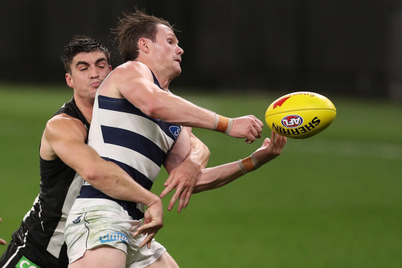 Cats star Patrick Dangerfield gets tackled by Magpie Brayden Maynard.