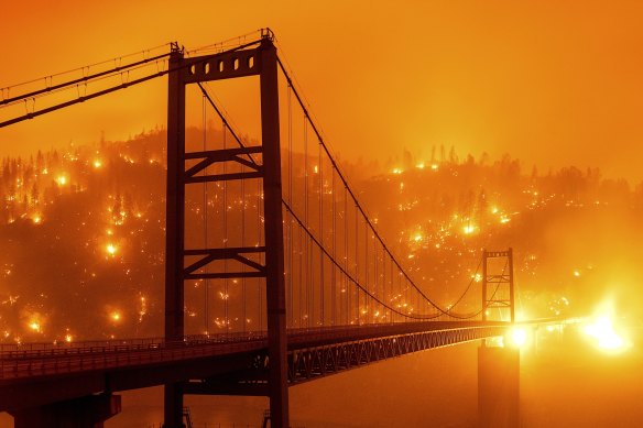 Embers light up a hillside behind the Bidwell Bar Bridge as the Bear Fire burns in Oroville, California during America’s deadly 2020 fire season.