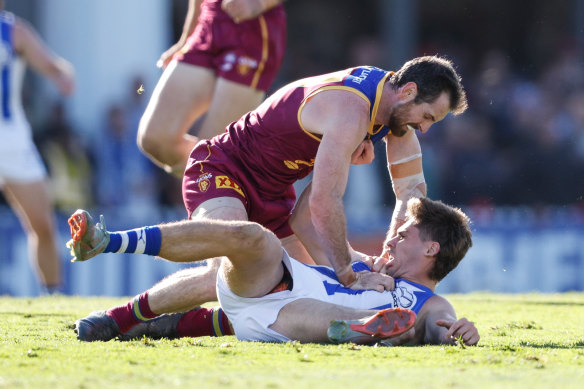 Kallan Dawson of the Kangaroos and Darcy Fort of the Lions wrestle.