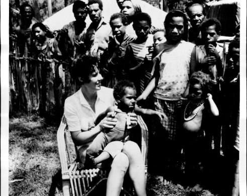 A pikinini man (child) sits worriedly in the lap of Dr Heather Greenfield in Papua-New Guinea, 1973.