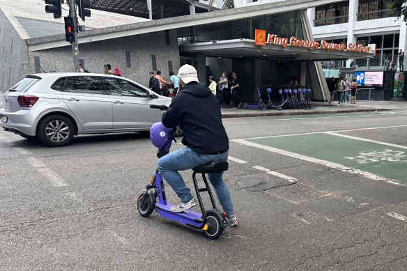 A man rides an e-scooter across Adelaide Street in Brisbane’s CBD in September 2023.