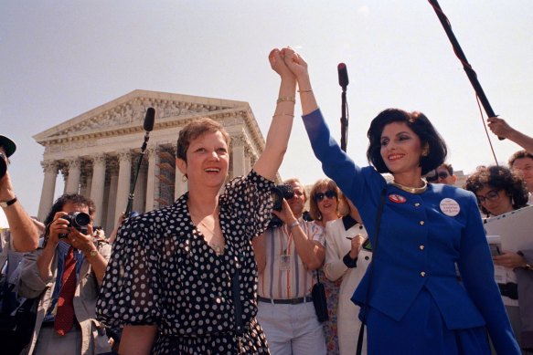 Norma McCorvey, Jane Roe in the 1973 court case, (left) and her attorney Gloria Allred hold hands outside the Supreme Court in Washington in 1989.