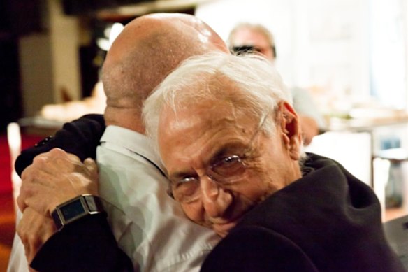 Architect Frank Gehry (facing camera) hugs the then-UTS Business School dean Roy Green at the opening of the “paper bag” building in 2015. 