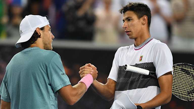 Lucas Pouille of France (left) shakes hands with Alexei Popyrin of Australia.