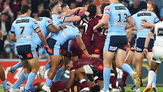 Selwyn Cobbo of the Maroons is attended to by Dane Gagai of the Maroons as tensions boil over.