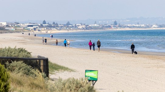 Walkers enjoying a stroll on Aspendale beach.