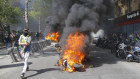 A man runs by a burning motorbike during a yellow vest demonstration in Paris, Saturday.