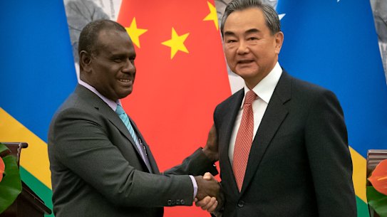 Solomon Islands Foreign Minister Jeremiah Manele, left, and Chinese Foreign Minister Wang Yi shake hands during a ceremony to mark the establishment of diplomatic relations between Solomon Islands and China.