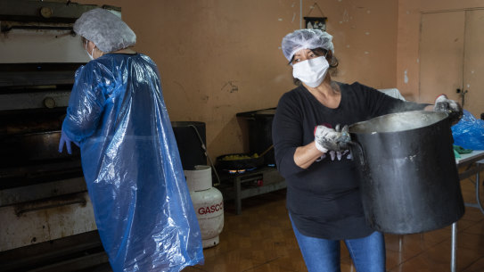 Social workers prepare food at a "olla comun" community kitchen in the Lo Hermida neighborhood of Santiago, Chile, on Monday, Aug. 17, 2020. The United Nations’ World Food Programme estimates that the Latin American and Caribbean nations in which it operates will see a surge of roughly 270% in the number of people facing severe food insecurity over the coming months.