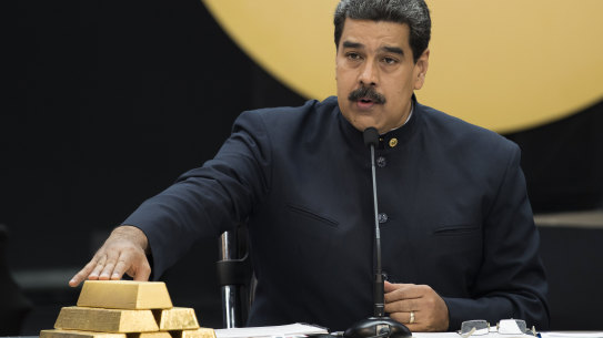Venezuelan President Nicolas Maduro touches gold bars at a press conference  in Caracas in 2018.
