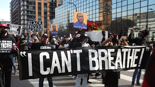 Demonstrators carry a banner during an ‘I Can’t Breathe’ Silent March For Justice in Minneapolis, Minnesota, in March 2021. Derek Chauvin knelt on George Floyd’s neck for nearly 9 minutes.