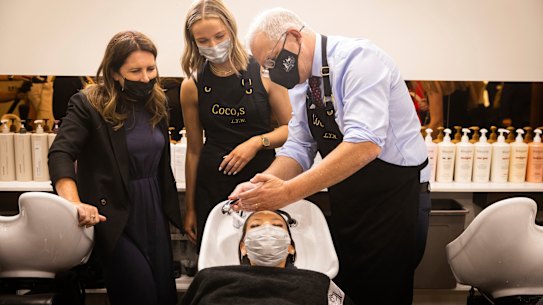 The Prime Minister took up a hose to wash the hair of apprentice Courtnie Trotter at a Mt Eliza salon on Friday.