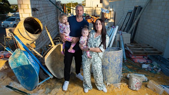 Cara and Jason Godwin with their two children, Sage, 2, and Summer, 8 months, at the construction site of their family home in Doubleview.
