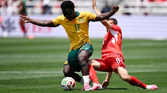 Nestory Irankunda of Australia competes for the ball against Remo Freuler of Switzerland.