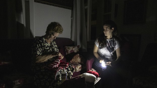 Residents sitting in torchlight during Beirut’s nightly power cuts. Some places will get electricity for only an hour or two a day. 