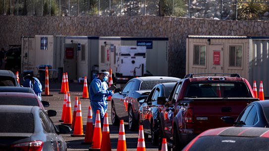 A medical worker wearing personal protective equipment (PPE) registers a person in a vehicle at a COVID-19 drive-thru testing site in El Paso, Texas.