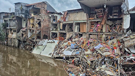 A building on the edge of the Badung River in Denpasar City collapses after being hit by the floods.