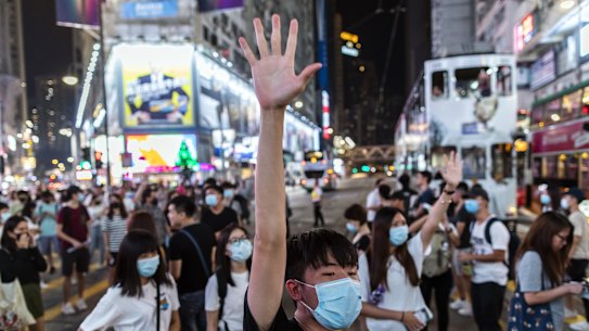 A demonstrator raises his hand as he blocks traffic on Hennessy Road during a protest in the Causeway Bay district of Hong Kong. 