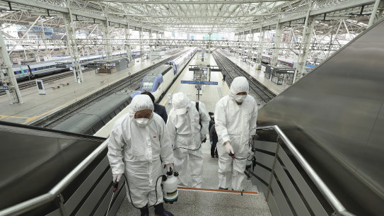 Workers wearing protective gears spray disinfectant as a precaution against the new coronavirus at Seoul Railway Station in Seoul, South Korea, Tuesday, Feb. 25, 2020. China and South Korea on Tuesday reported more cases of a new viral illness that has been concentrated in North Asia but is causing global worry as clusters grow in the Middle East and Europe. (Jin Yeon-soo/Yonhap via AP)