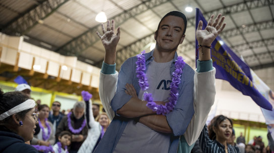 A supporter plays with a cardboard cutout of Daniel Noboa as she celebrates the early election results in Quito, Ecuador.