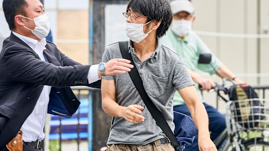 Tetsuya Yamagami, left, holding a DIY weapon, is detained after former prime minister Shinzo Abe was assassinated.