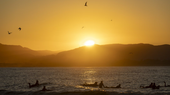 Surfers enjoying the sunset in Byron Bay before the forecast weather change.