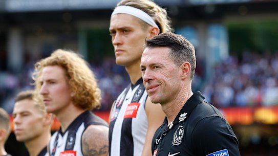 Coach Craig McRae stands alongside Collingwood skipper Darcy Moore during the pre-game ceremony on Anzac Day.