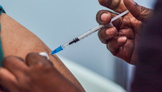 A health worker administers a COVID-19 vaccine 