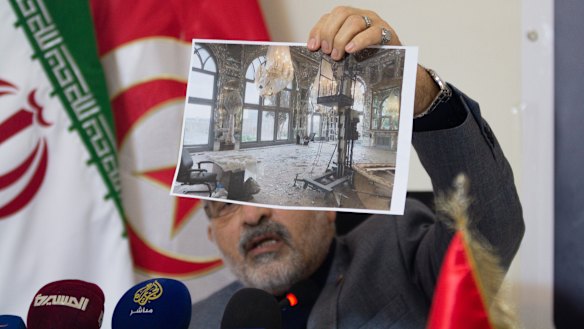 Iranian ambassador to Tunisia Mir Massoud Hosseinian shows an image of damage to Tehran’s historic Golestan Palace.