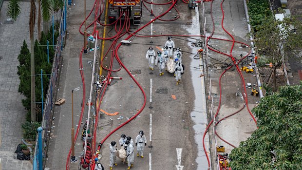 Police carries bodies of victims out of Wang Fuk Court. 