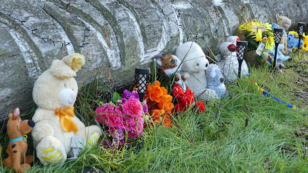 Toys, flowers and candles have been left in tribute near the home in Coonabarabran.
