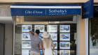 Pedestrians browse properties in the window of a Sotheby’s real estate office in Saint-Jean-Cap-Ferrat.