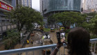 A pedestrian takes photographs of a flooded road following heavy rainstorms in Hong Kong on Friday.