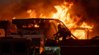 As dawn breaks firefighters continue to battle wind and fire as homes go up in flames in Malibu along Pacific Coast.