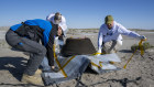 Lockheed Martin mission operations assurance lead Graham Miller, and recovery specialists Michael Kaye and Levi Hanish prepare the sample return capsule from NASA’s OSIRIS-REx mission for transport after it landed.