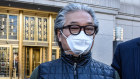 Bill Hwang departs federal court in New York where he pleaded not guilty. He agreed to pay $US5 million in cash and pledged two properties to secure a $US100 million bond.