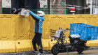 A delivery worker hands an order over a fence at a neighbourhood during a lockdown in Shanghai.